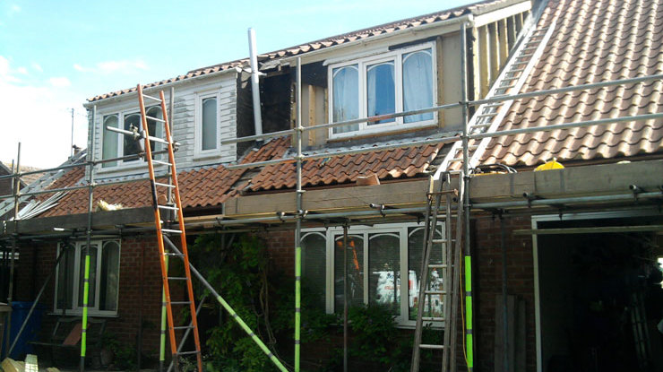 Erecting scaffolding in preparation for re-roofing